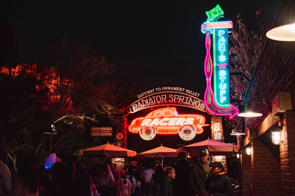 Radiator Springs Racers ride wait time sign at night with neon lit up