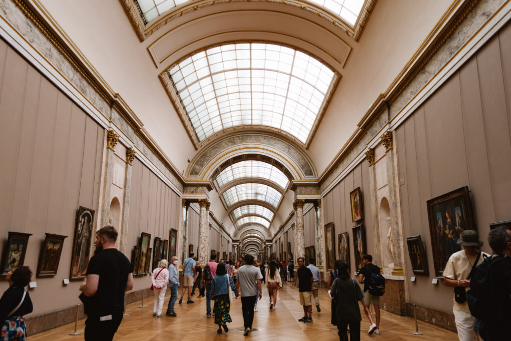 crowded Louvre hallway with arched ceiling with sky lights