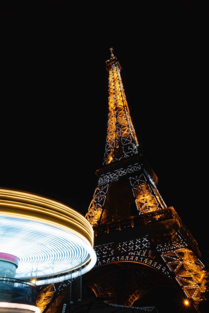 Eiffel Tower carousel lit up next to Eiffel Tower show