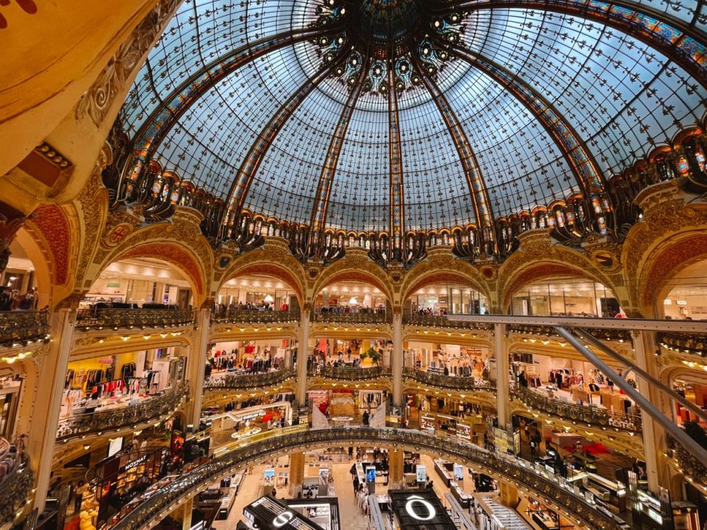 Stained glass dome ceiling inside Paris mall with lavish decor